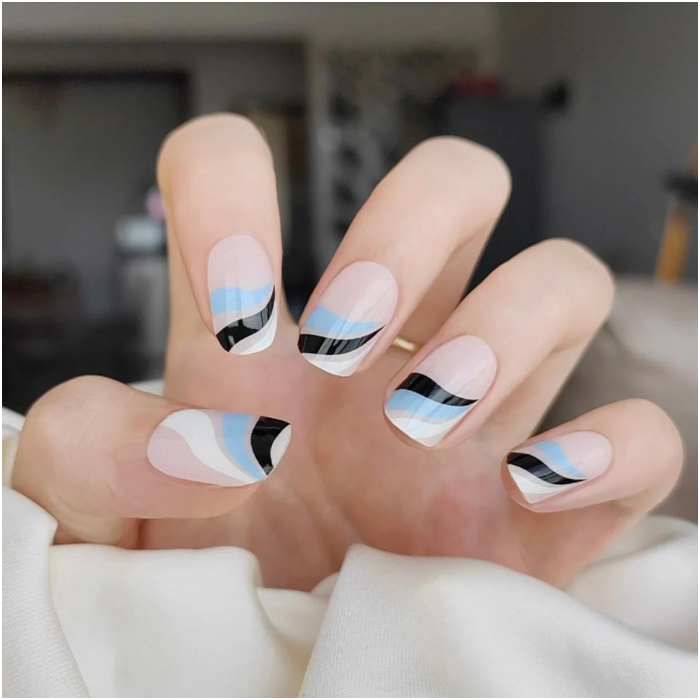 Nails adorned with Ocean Swirl wraps, showcasing a dynamic teal marble design.