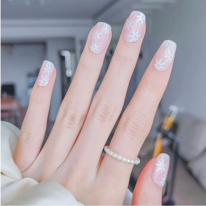 Nails adorned with Pink Daisies gel wraps combined with solid pastel accents for a playful look.