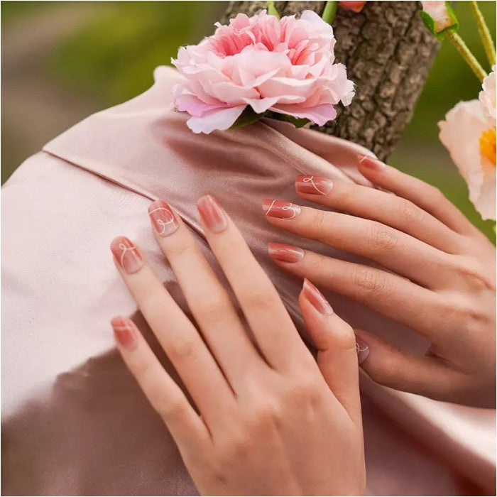 Fingers showcasing Blushing Sweetheart gel nail wraps, highlighting a delicate pink manicure with a hint of sparkle.
