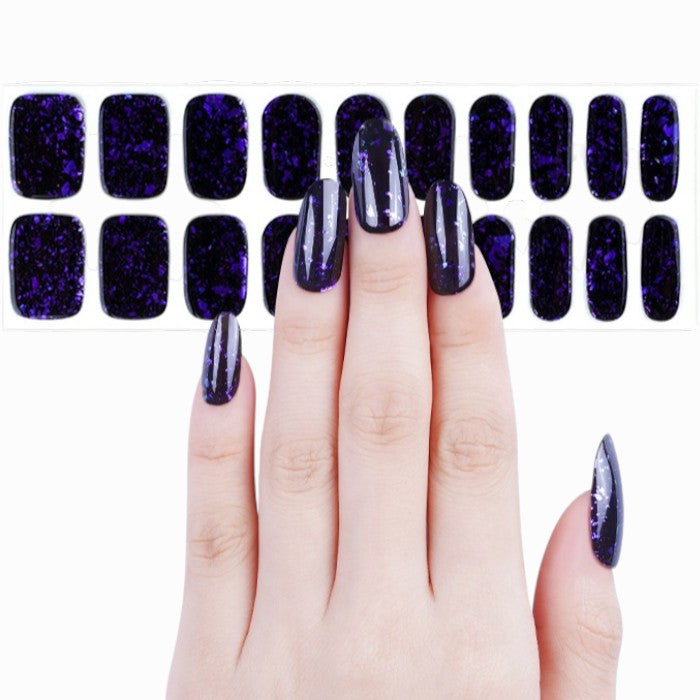 Sticker sheet presenting black gel nail wraps with multicolored glitter in assorted sizes.