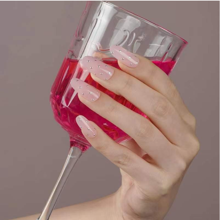 Nails adorned with Fairytale gel wraps complemented by white floral nail art for an enchanting look.